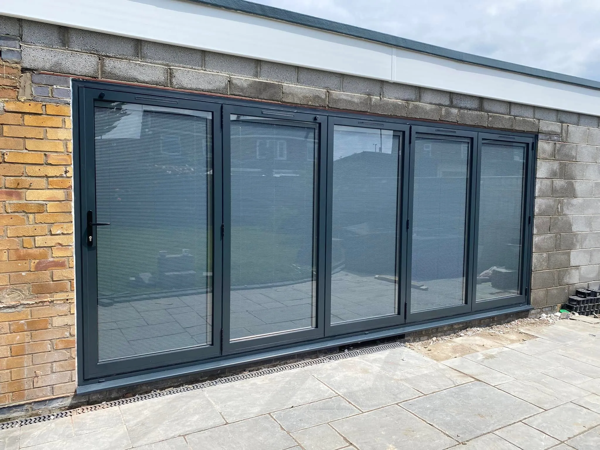 Five-panel anthracite grey aluminium bi-fold doors on an extension
