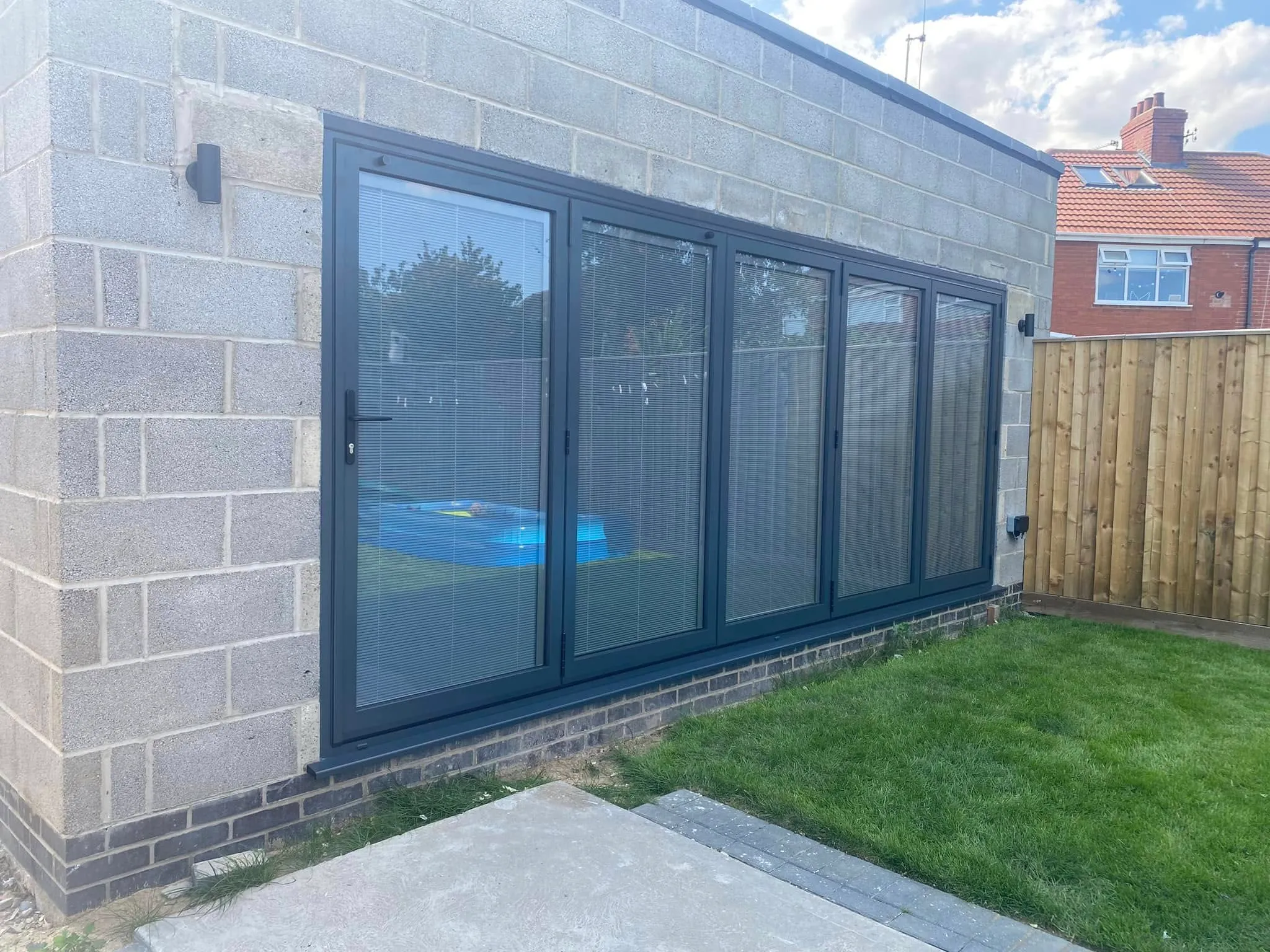 Anthracite grey bi-fold doors fitted on an outbuilding