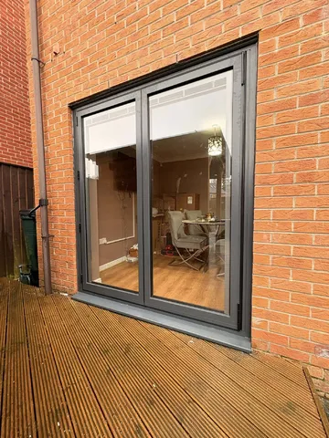 New Anthracite Grey bifolding doors opening onto the garden decking