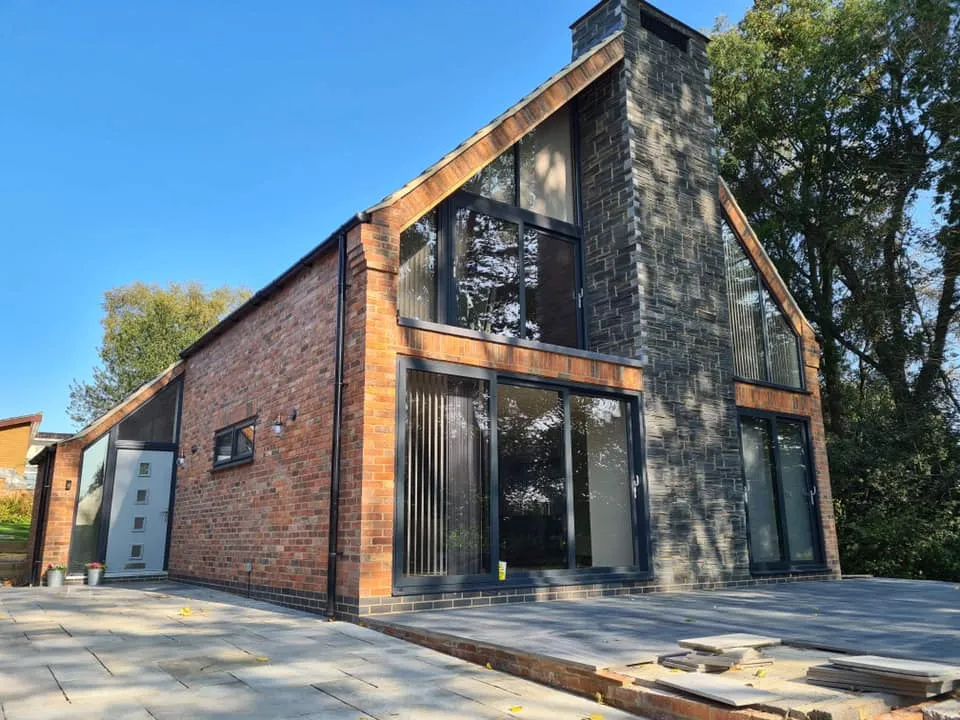 New build with anthracite grey gable glazing and bi-fold doors
