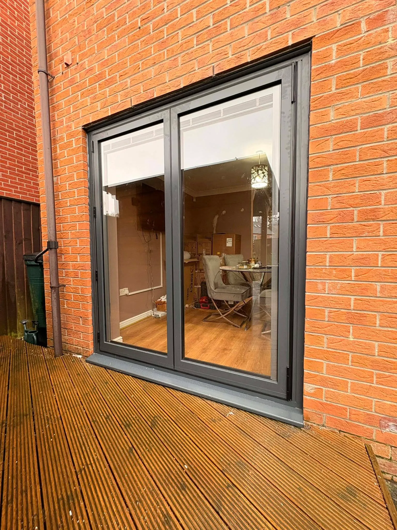Anthracite grey sliding patio doors opening onto timber decking